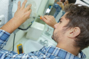 tradesman,fixing,electrical,issue,with,hand,dryer